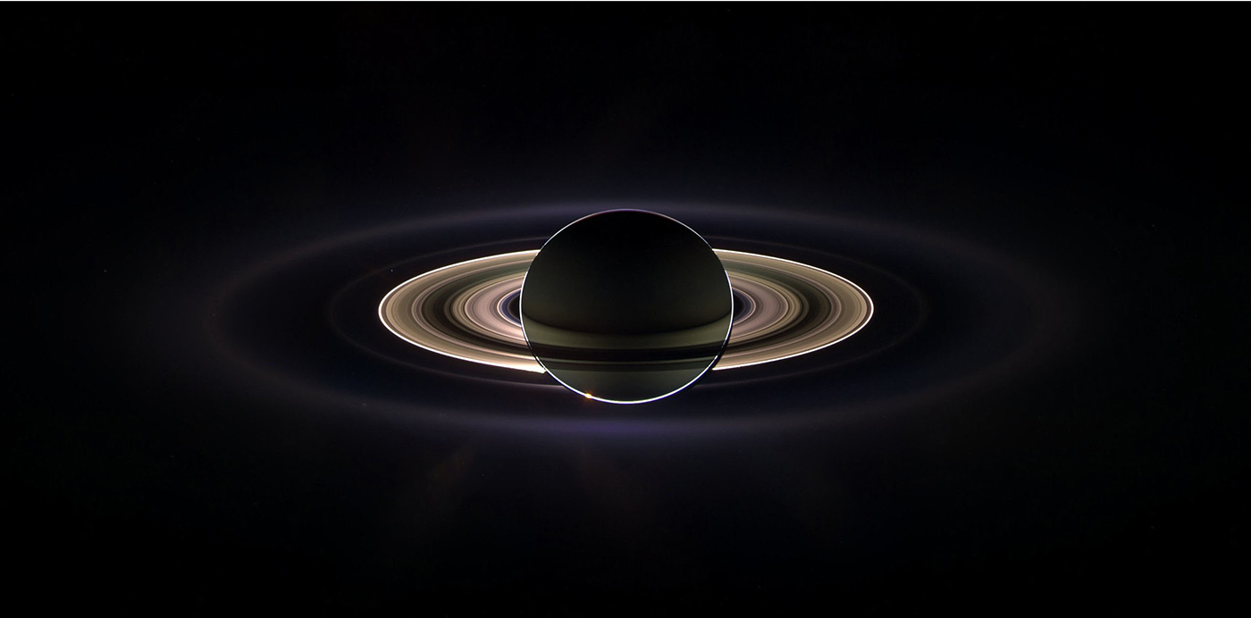 
Mens kjempeplaneten Saturn skygget for det blendende sollyset kunne romsonden Cassini studere planeten og dens ringer som aldri tidligere. Tidligere ukjente ringer ble oppdaget, og vår egen hjemplanet kunne også skimtes som en liten prikk, til venstre rett over de lysende hovedringene. Dette flotte panoramabildet ble til ved å sette sammen 165 bilder tatt med Cassinis vidvinkelkamera i løpet av nærmere tre timer 15. september 2006. Fargene i bildet er generert ved å legge sammen bilder tatt gjennom ultrafiolett, infrarødt og klart filter og justere fargebalansen for å få tilnærmet naturlige farger.Lambdatrykk (NASA/JPL-Caltech/Space Science Institute og Susanne Pieth, German Aerospace Center)