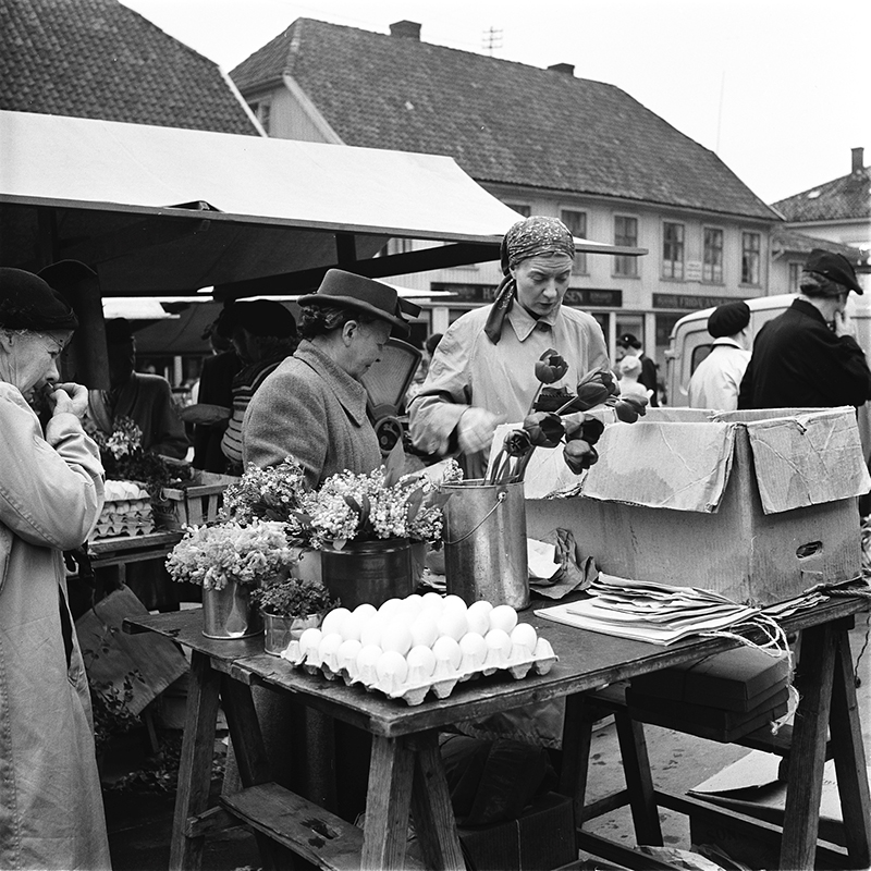 Elisabeth Meyer, "Flowers, eggs, vegetables and chicken are some of the many goods housewives in Tønsberg fetch at the town square" 1940s. Collection of Preus museum