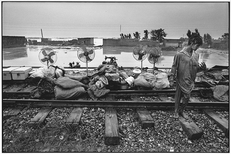 ©Rune Eraker, Pakistan, 2010
Water from the great flood is about to withdraw and the victims of the flood try to save what is possible
from the destroyed houses on the rails that lie a couple metres above floodwater near Risalpur. The UN called this flood the largest humanitarian disaster in our times. More than 20 million Pakistanis were affected.